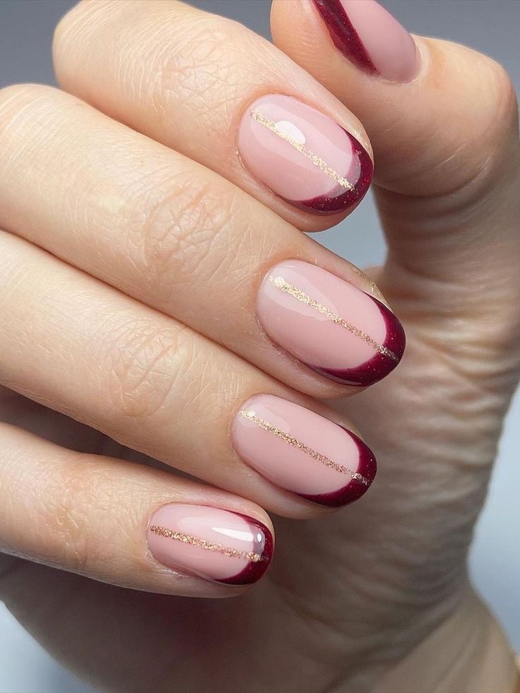 Chic Nude and Burgundy Nail Design with Elegant Gold Accents