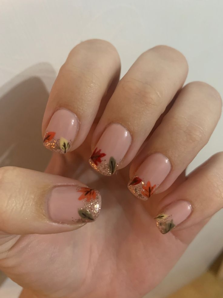 Elegant Floral Nail Design with Pink Base and Autumn Motifs Enhanced by Gold Glitter.