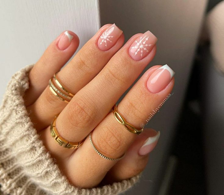 Chic Winter Nail Design: Soft Nude Base with White Snowflakes and Elegant French Tips.