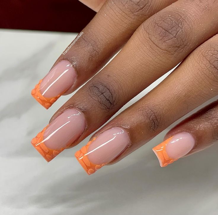 Chic Nude and Vibrant Orange Nail Design with Textured Tips