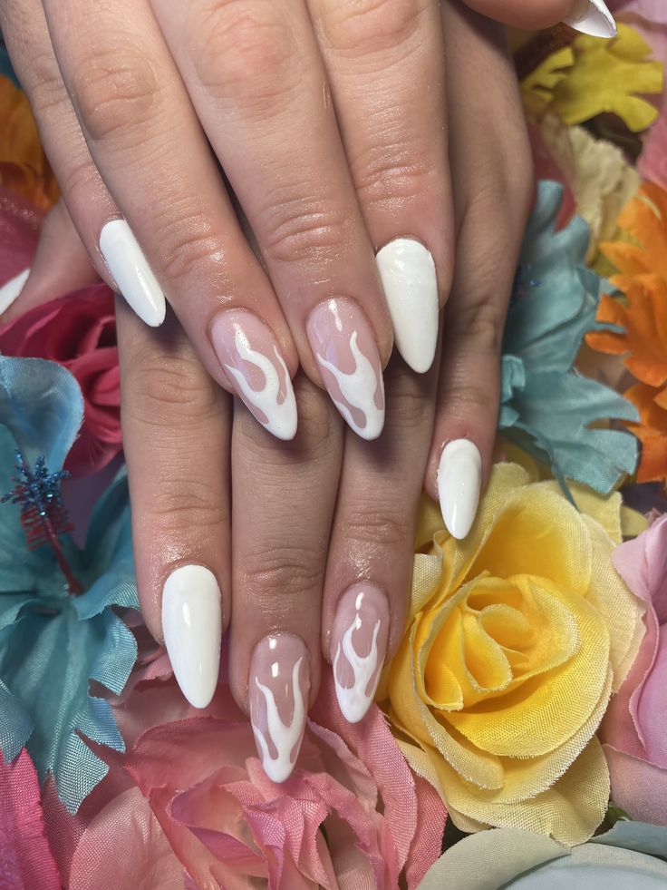 Dramatic Flame-Inspired Nail Design in White and Nude Against a Floral Backdrop.