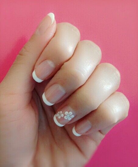 Chic French Tip Nail Design with Floral Accents for a Sophisticated Touch.