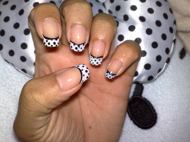 Chic Polka Dot Nail Design: Elegant French Tips with a Modern Twist.