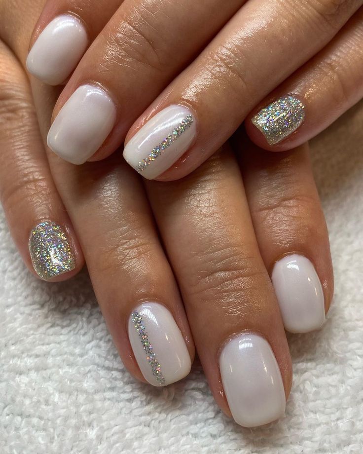 Sophisticated Glossy White Nail Design with Shimmering Glitter Accents.