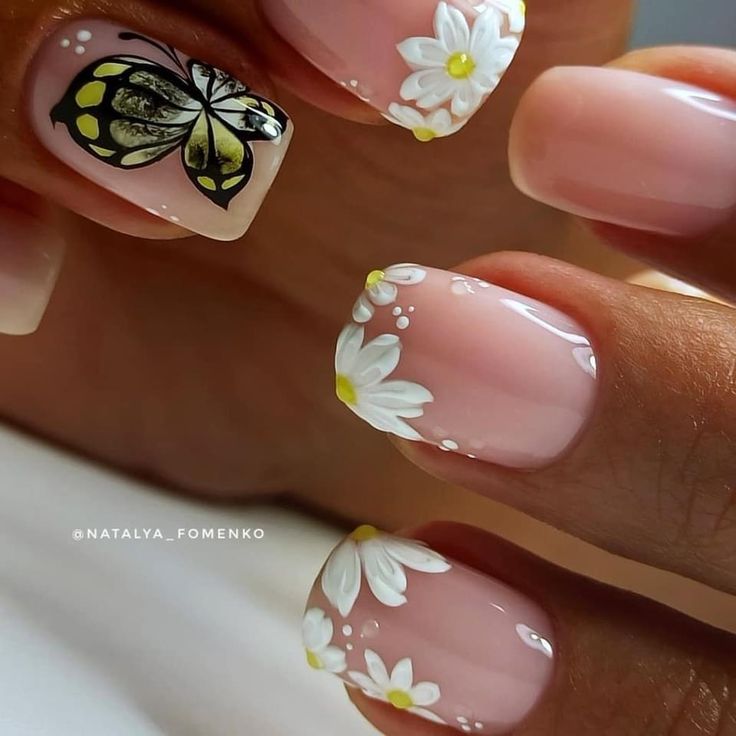 Elegant Floral Nail Design with White Daisies and a Vibrant Butterfly on a Soft Nude Base.