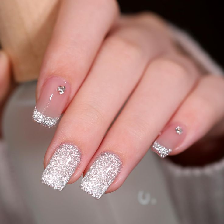 Elegant Sparkling French Tip Nails with Rhinestone Embellishments.