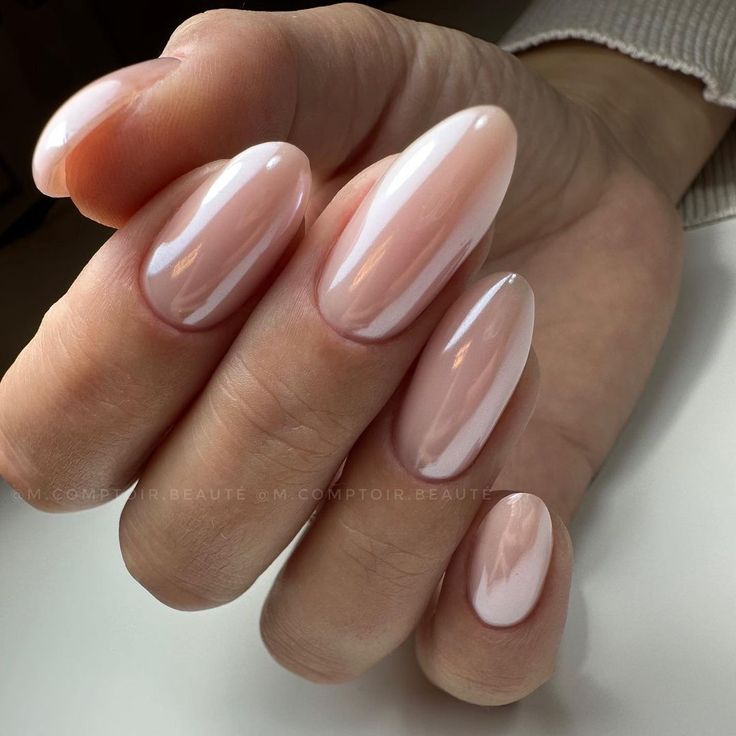 Elegant Almond-Shaped Nails with Soft Pearlescent Finish and Sheer Blush Tones: A Sophisticated Minimalist Design.