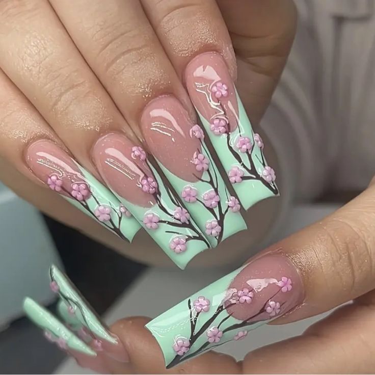 Chic Floral Nail Design with Soft Pink Blossoms on Mint Background and Intricate Branch Details.