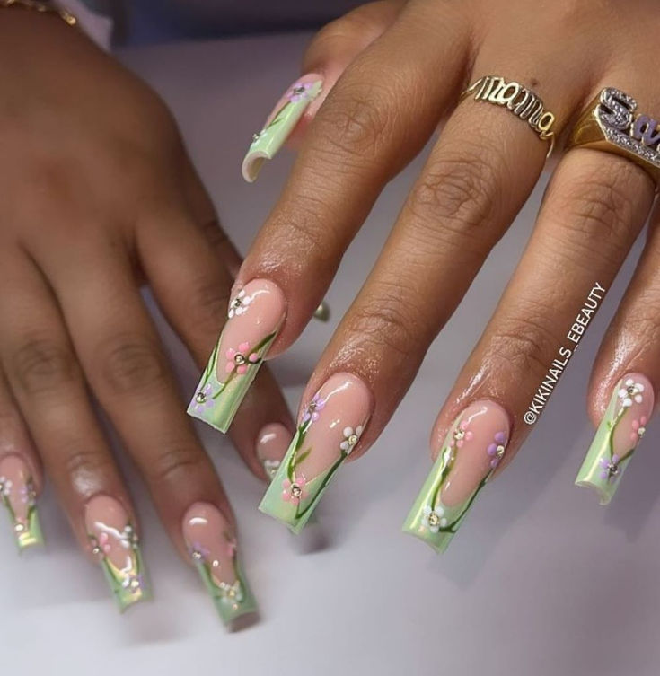 Elegant Floral Nail Design: Delicate Pink Hearts and White Blossoms with Soft Green Tips for a Whimsical Spring Look.