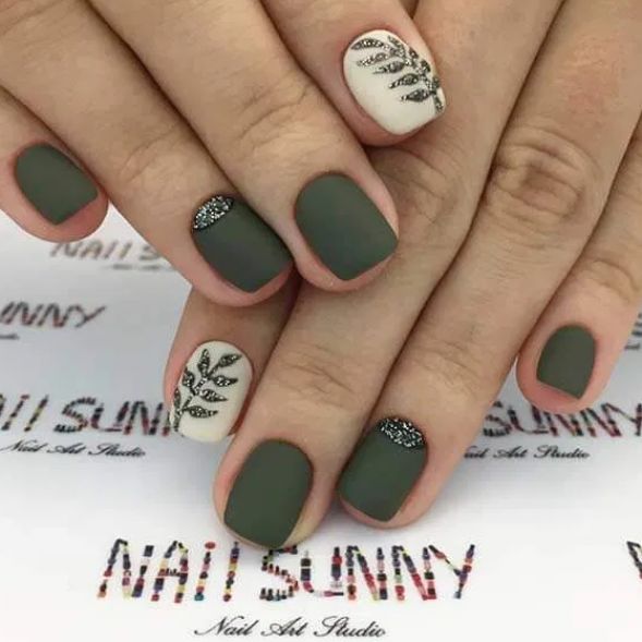 Elegant Matte Green and White Nail Design with Leaf Patterns and Sparkling Accents