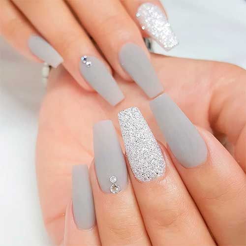 Elegant Matte Gray Nail Design with Glamorous Accents and Sparkly Elements.