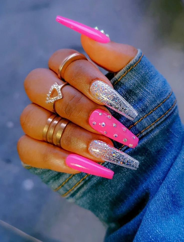 Bold and Glamorous Long Pointed Nail Design with Hot Pink, Sparkling Silver, and Decorative Studs.