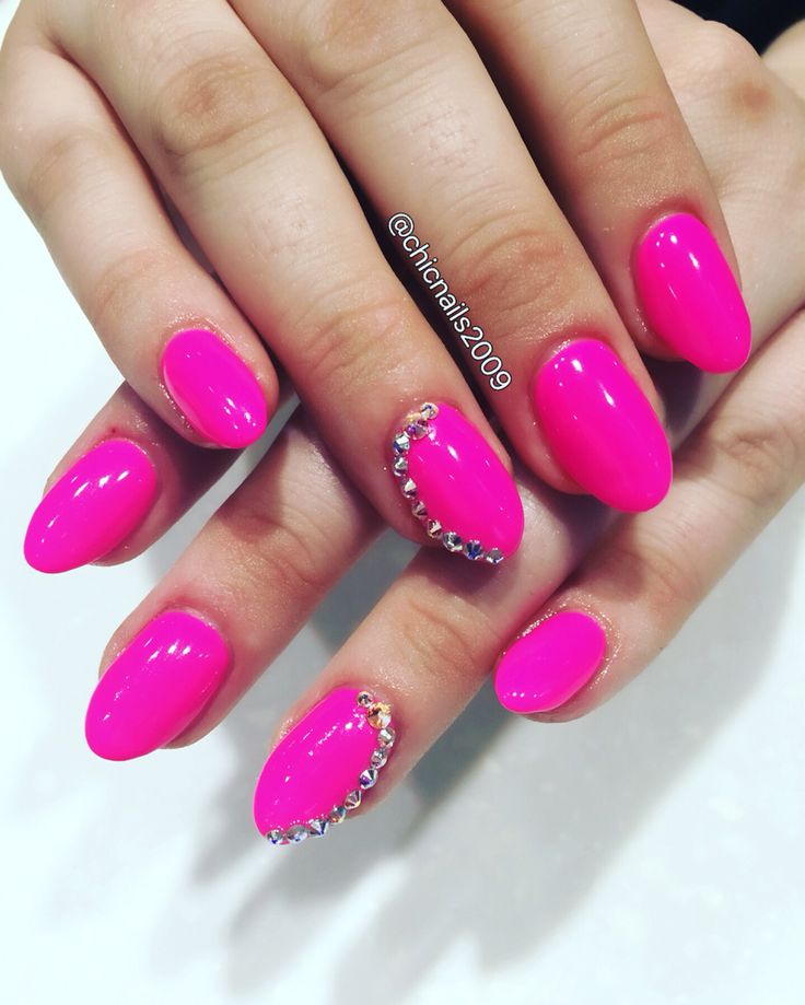 Bold Glossy Pink Nails with Glamorous Rhinestone Accent.