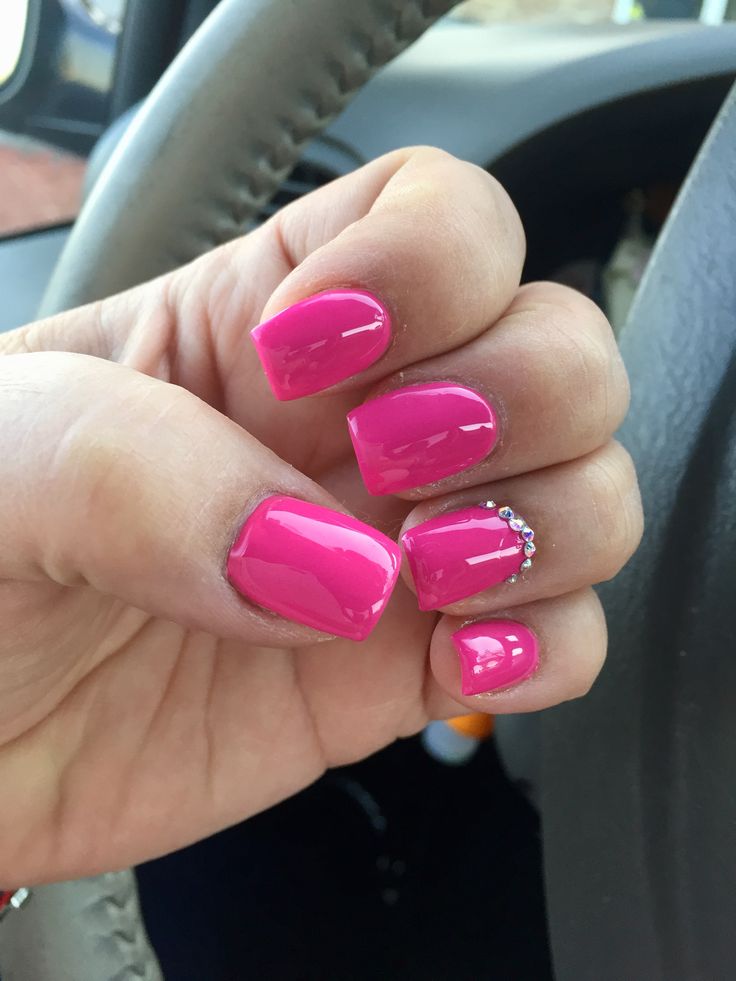 Bold and Glamorous: Vibrant Pink Nail Design with Glossy Finish and Rhinestone Accent.