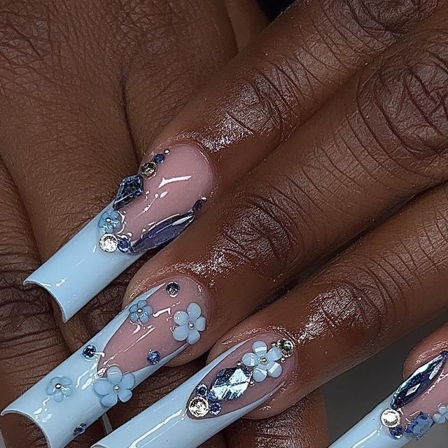 Sophisticated Elegant Floral Nail Design in Pastel Blue and Nude with Gemstone Embellishments.