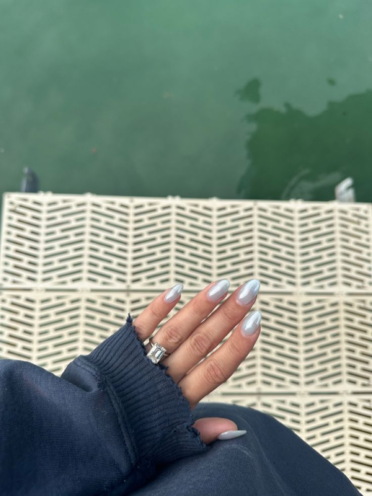 Elegant Silver Nails Enhance Sophistication Against a Muted Outfit and Serene Water Backdrop.