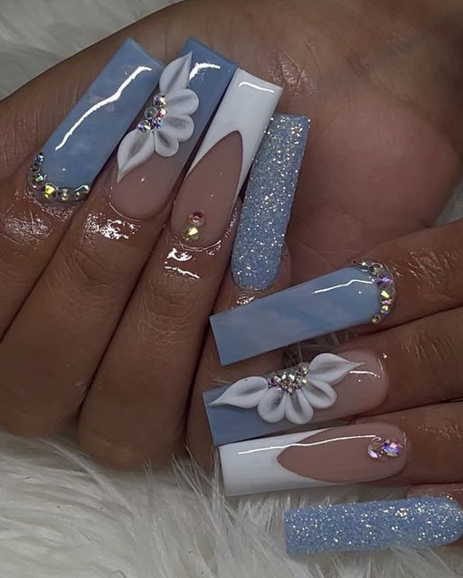 Elegant Nail Design: Soft Blue and Neutral Tones with Floral Motifs and Rhinestones