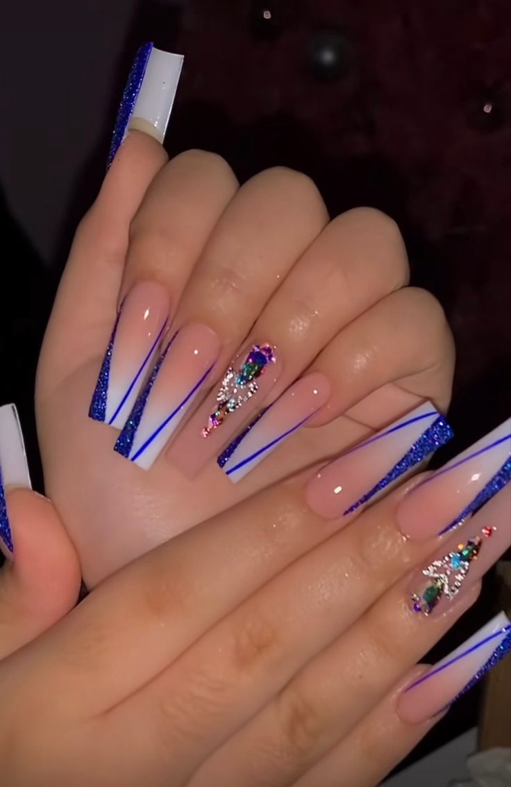 Elegant Blue Glitter Coffin Nails with Striking Striping and Gemstone Accents.