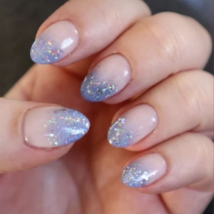 Dreamy Soft Blue Ombre Nail Design with Iridescent Finish and Glamorous Sparkling Accents.