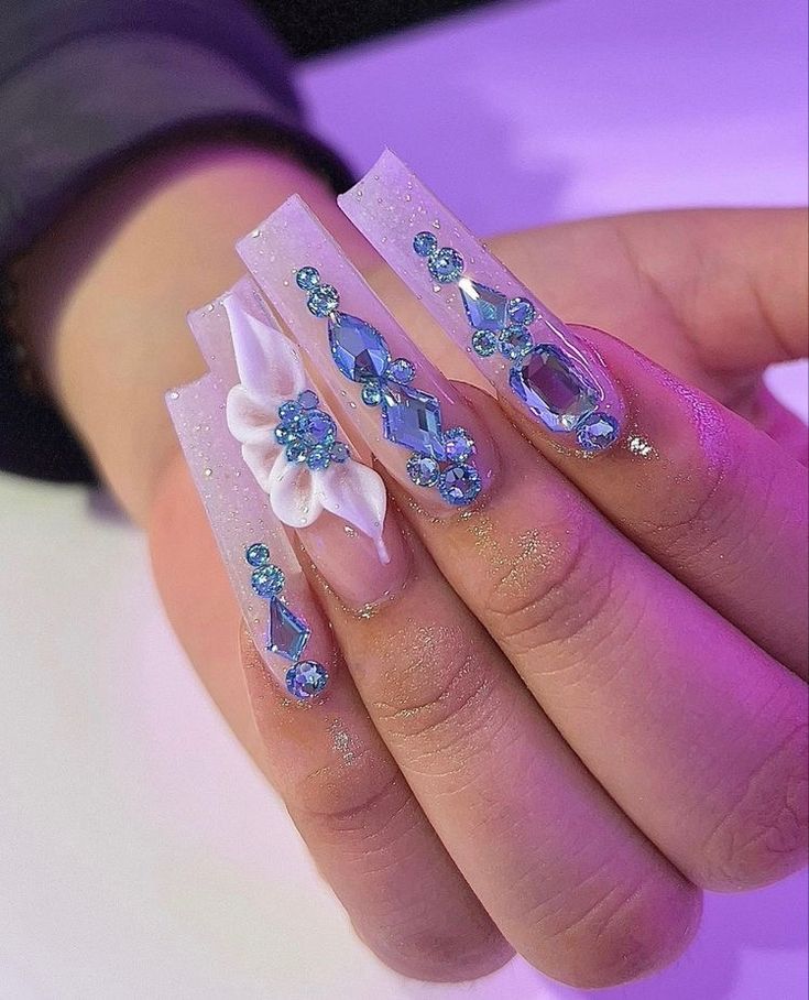 Elegant Long Nail Art Featuring 3D Floral Accents and Shimmering Blue Gemstones