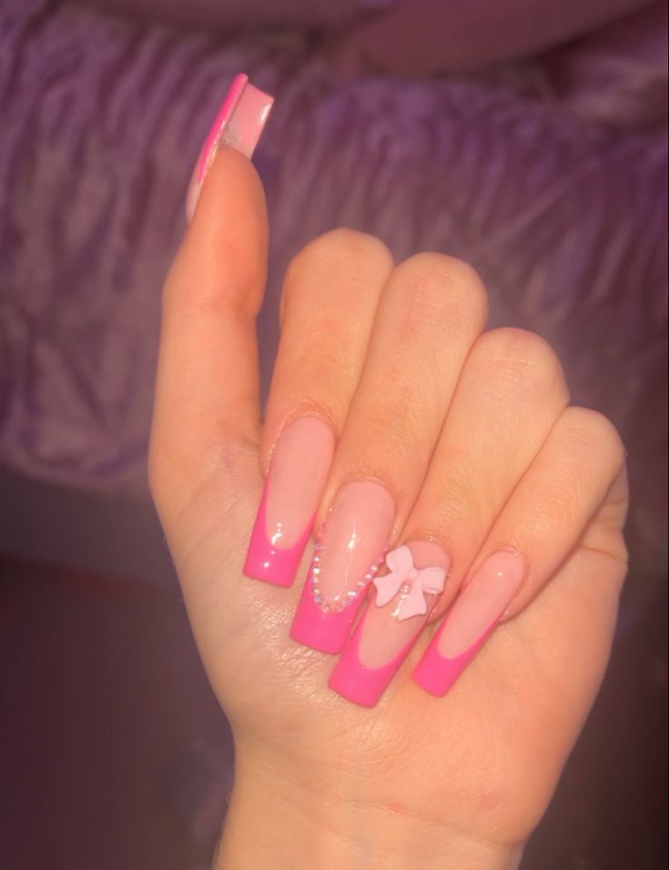 Glossy Nude Base with Vibrant Pink Tips and Sparkling Pink Bow Accents