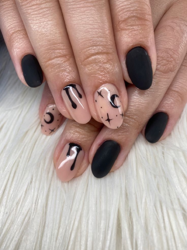 Celestial-Inspired Matte Black and Nude Nail Art with Abstract Patterns.