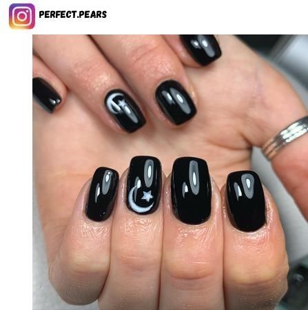 Chic Glossy Black Nail Design with Whimsical Moon and Star Accents.