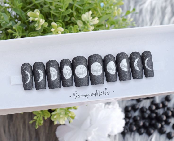 Cosmic-Themed Nail Set: Matte Black Base with Intricate Lunar Designs.