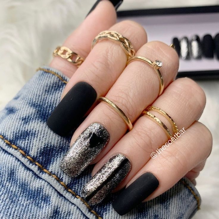 Chic Nail Design: Matte Black and Glittery Silver with Elegant Heart Accent and Gold Rings.