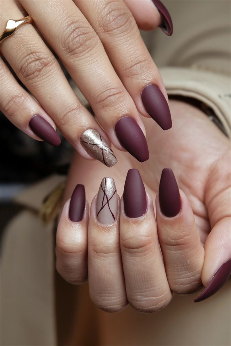 Chic Burgundy Nails with Glossy Gold and Nude Accents for a Sophisticated Look.