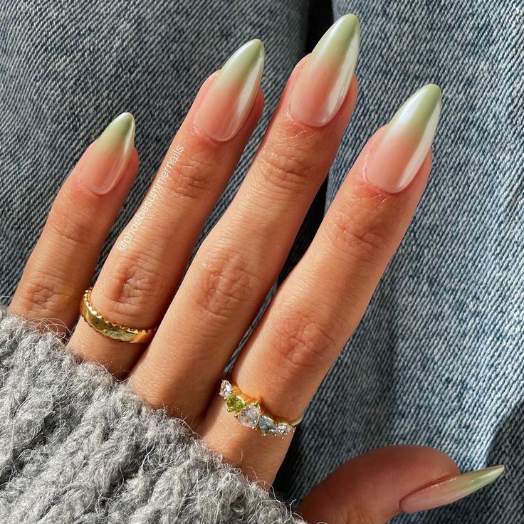 Elegant Ombre Almond-Shaped Nails: Soft Green to Nude Gradient with Stylish Rings.