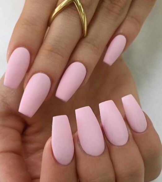 Chic Matte Pink Nails with Long Tapered Shape and Delicate Gold Ring for Modern Elegance.