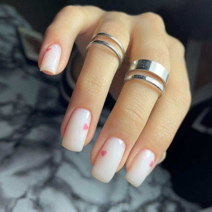 Romantic Ombre Nail Design with Heart Accents and Modern Silver Rings.