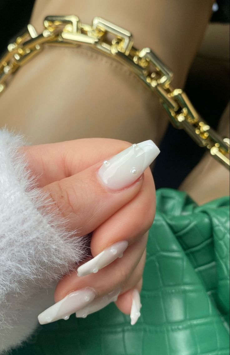 Chic Elegant Manicure: Long Glossy White Nails with Pearl Accents and Subtle Gradient Effect.