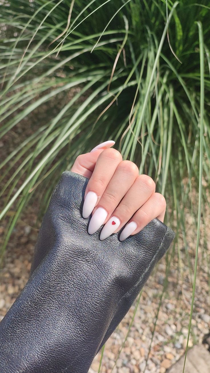 Elegant Matte White Oval Nails with Playful Red Dot Accent.