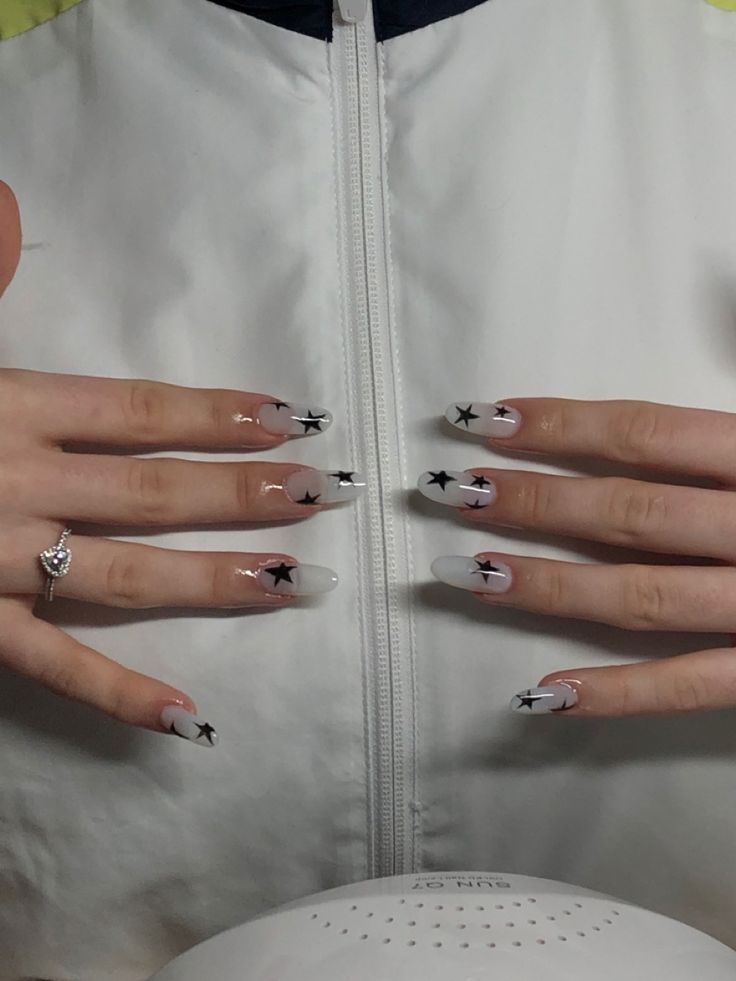 Chic Nail Design: Soft Whites and Pastels with Artistic Black Star Patterns