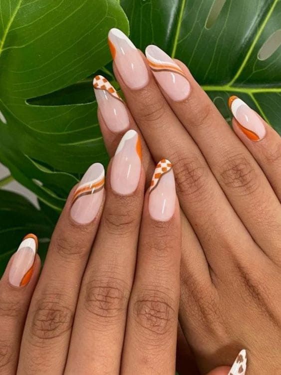 Chic Nail Design: Soft Nude with Bold Orange Accents and Geometric Patterns