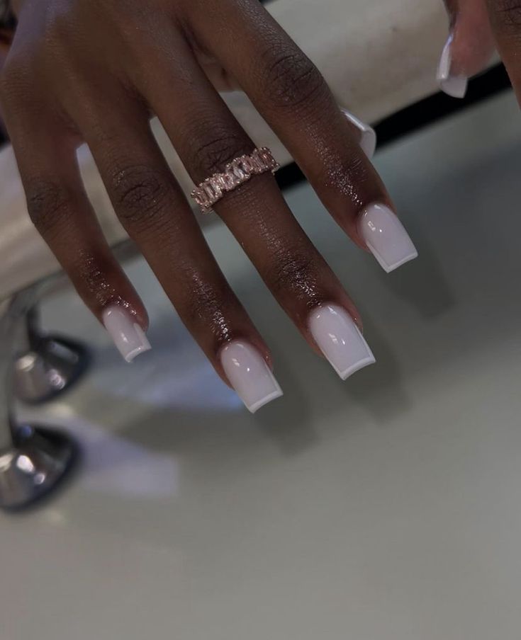 Chic Glossy White Square Nails Paired with Elegant Rose Gold Ring for a Sophisticated Look.