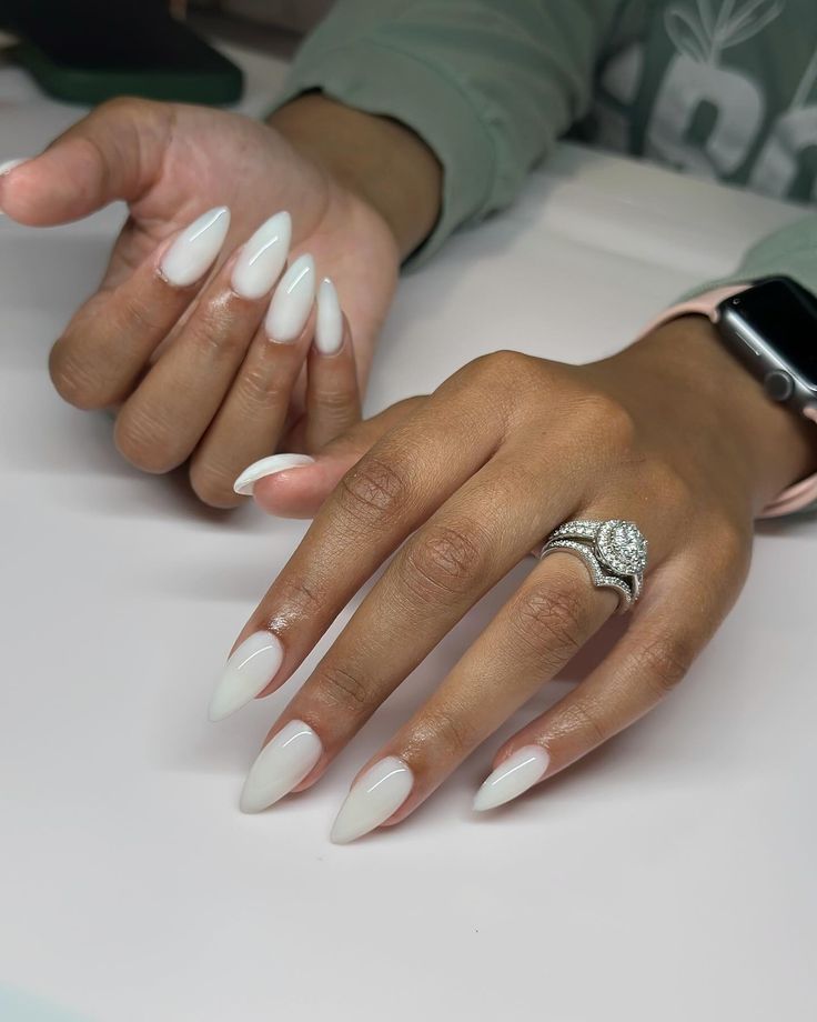 Sleek Almond-Shaped Nails in Glossy White Paired with a Statement Ring for a Chic Look.