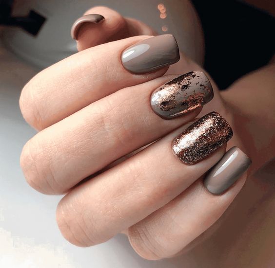 Sophisticated Taupe and Bronze Nail Design with Glam Gold Glitter Accents.