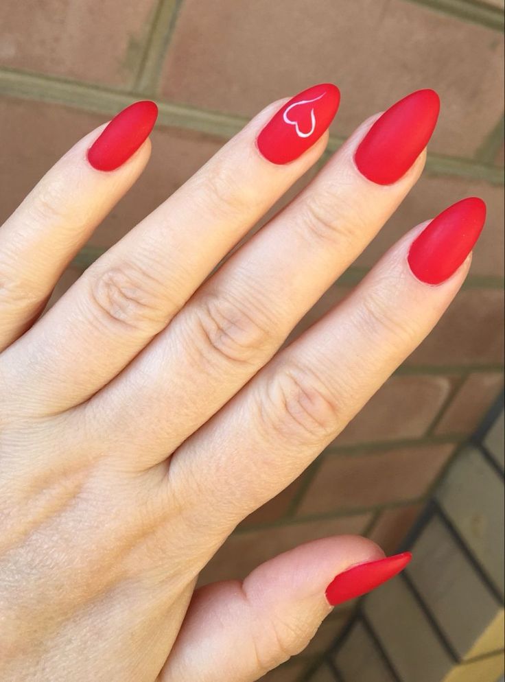 Elegant Red Matte Nails with Heart Accent for Dramatic Sophistication.