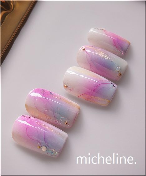 Sophisticated Ombre Nail Design: Pink and Lavender with Glitter and Gem Accents.