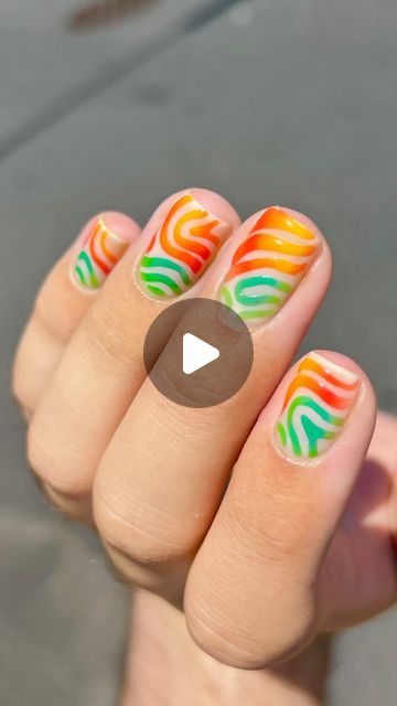 Bold Summer Nail Design with Vibrant Wavy Patterns in Orange, Green, and Yellow.