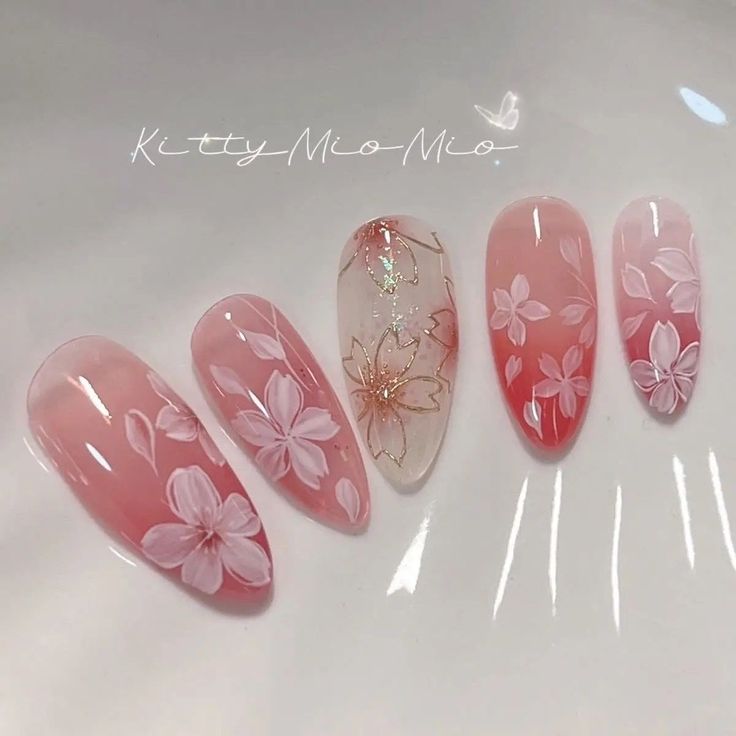 Elegant Floral Nail Design: Soft Pink Hues with Intricate White Blossoms and Sparkling Accent.