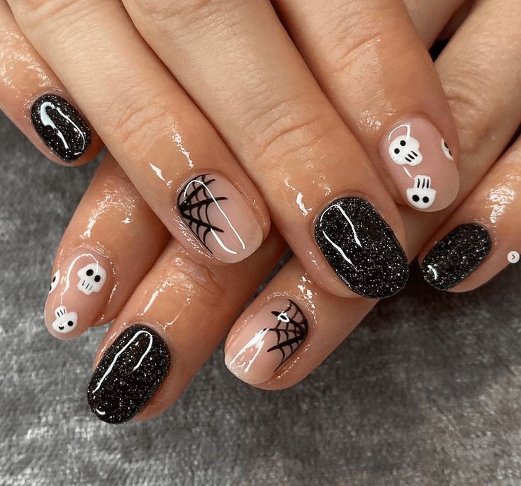 Whimsical Halloween Nail Design with Black and Nude Shades, Ghosts, Spider Webs, and Sparkling Glitter.