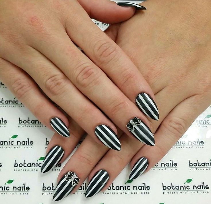 Elegant Black and White Striped Nails with Matte, Glossy Finishes and Intricate Embellishments.