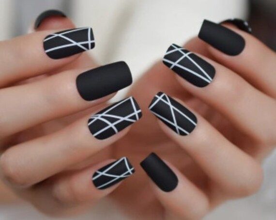 Elegant Matte Black Nail Design with Delicate White Stripes for Versatile Style.