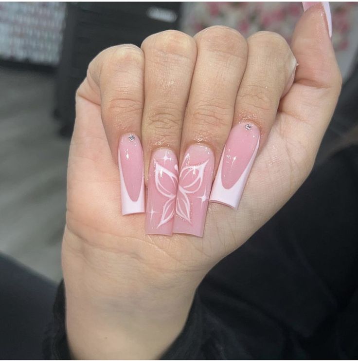 Elegant Pink Floral Nail Design with French Tips and Shimmery Accents.