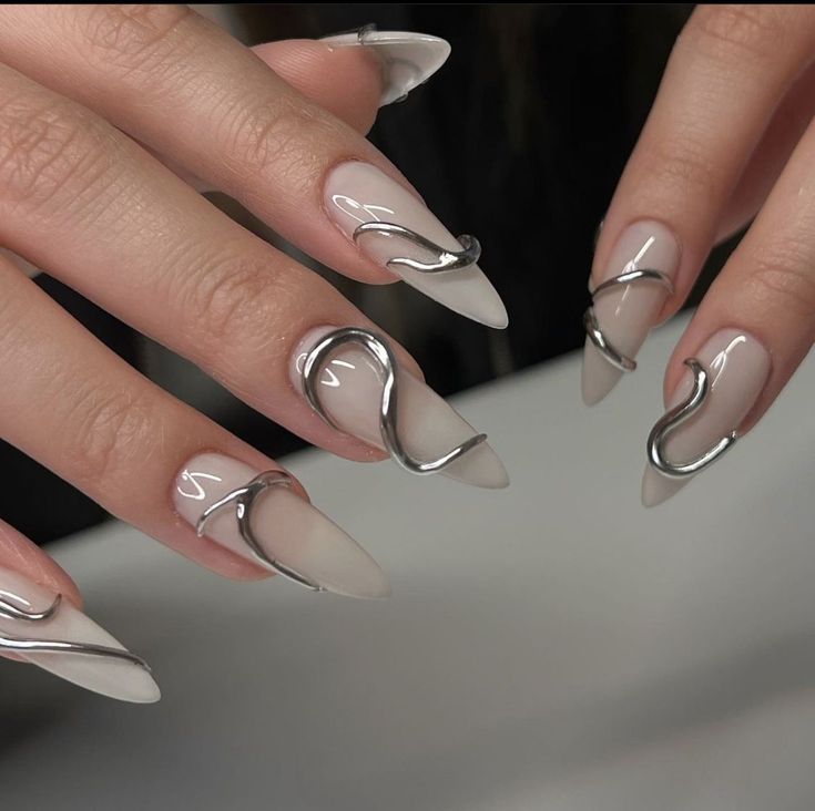 Elegant Almond-Shaped Nails with Glossy Beige Base and Metallic Silver Accents.