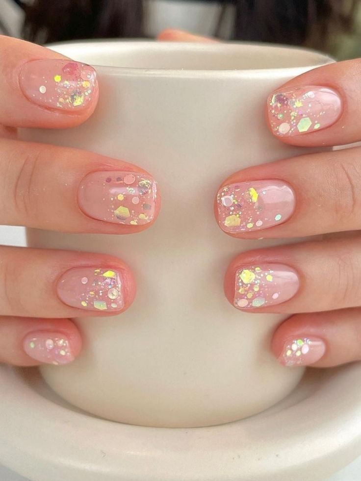 Chic Soft Pink Nail Design with Iridescent Glitter Accents for Elegant Playfulness.